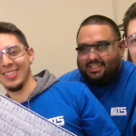 Four Brownson students wearing blue Brownson shirts smile at the camera